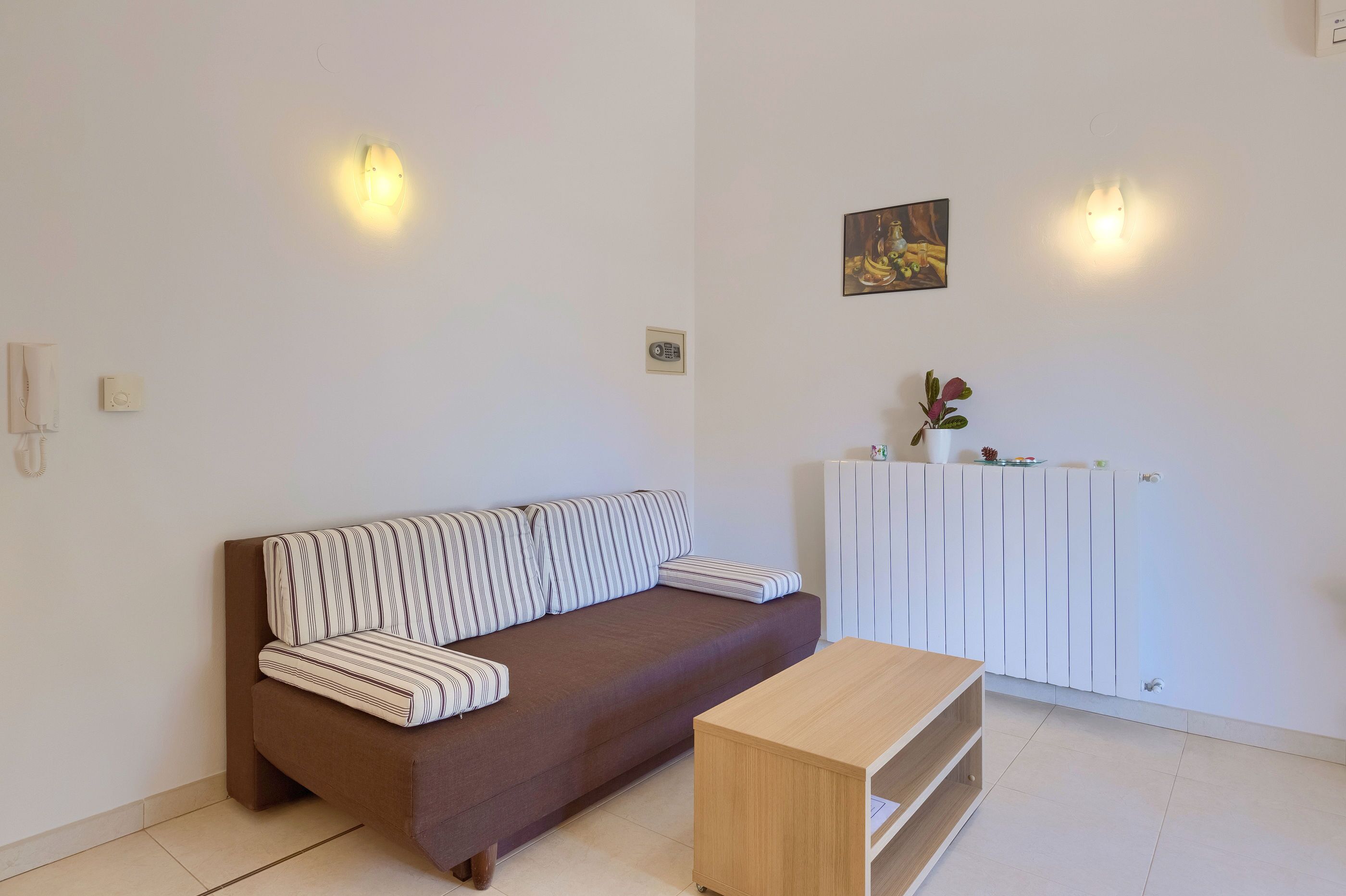 Un salon moderne avec un canapé marron, une table basse en bois et un meuble blanc.