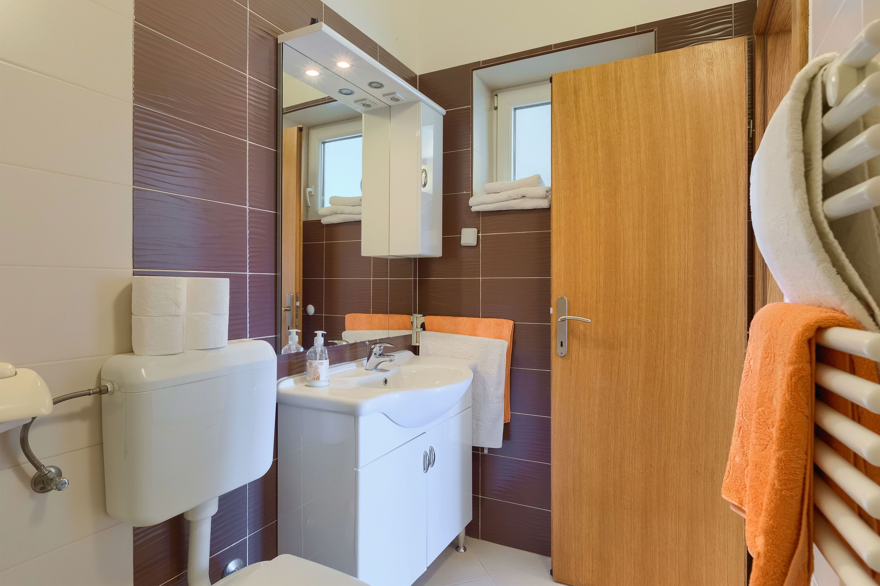 Ein Badezimmer mit Toilette, Waschbecken und Spiegel.