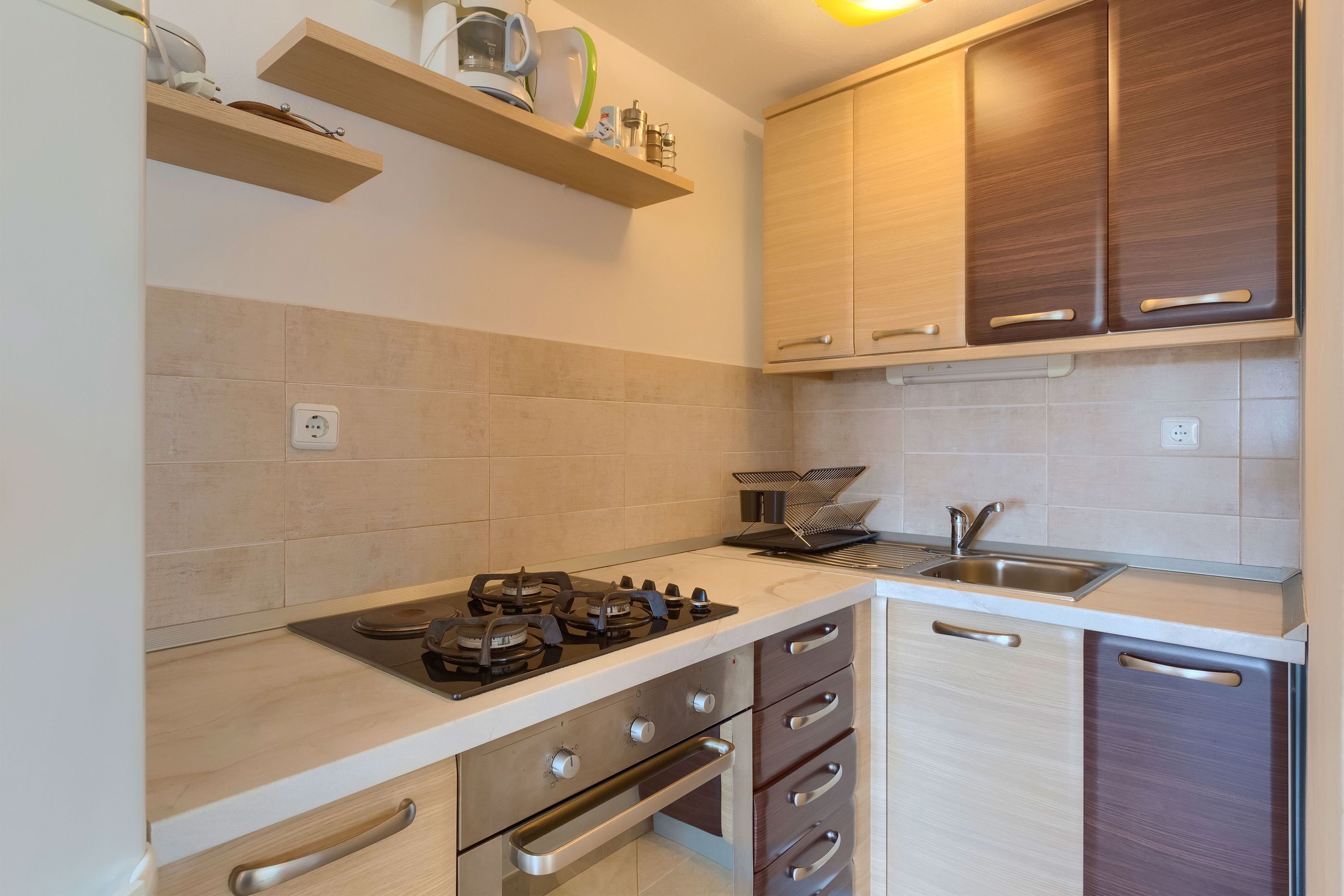 A modern kitchen with a gas stove, wooden cabinets, and a built-in dishwasher.