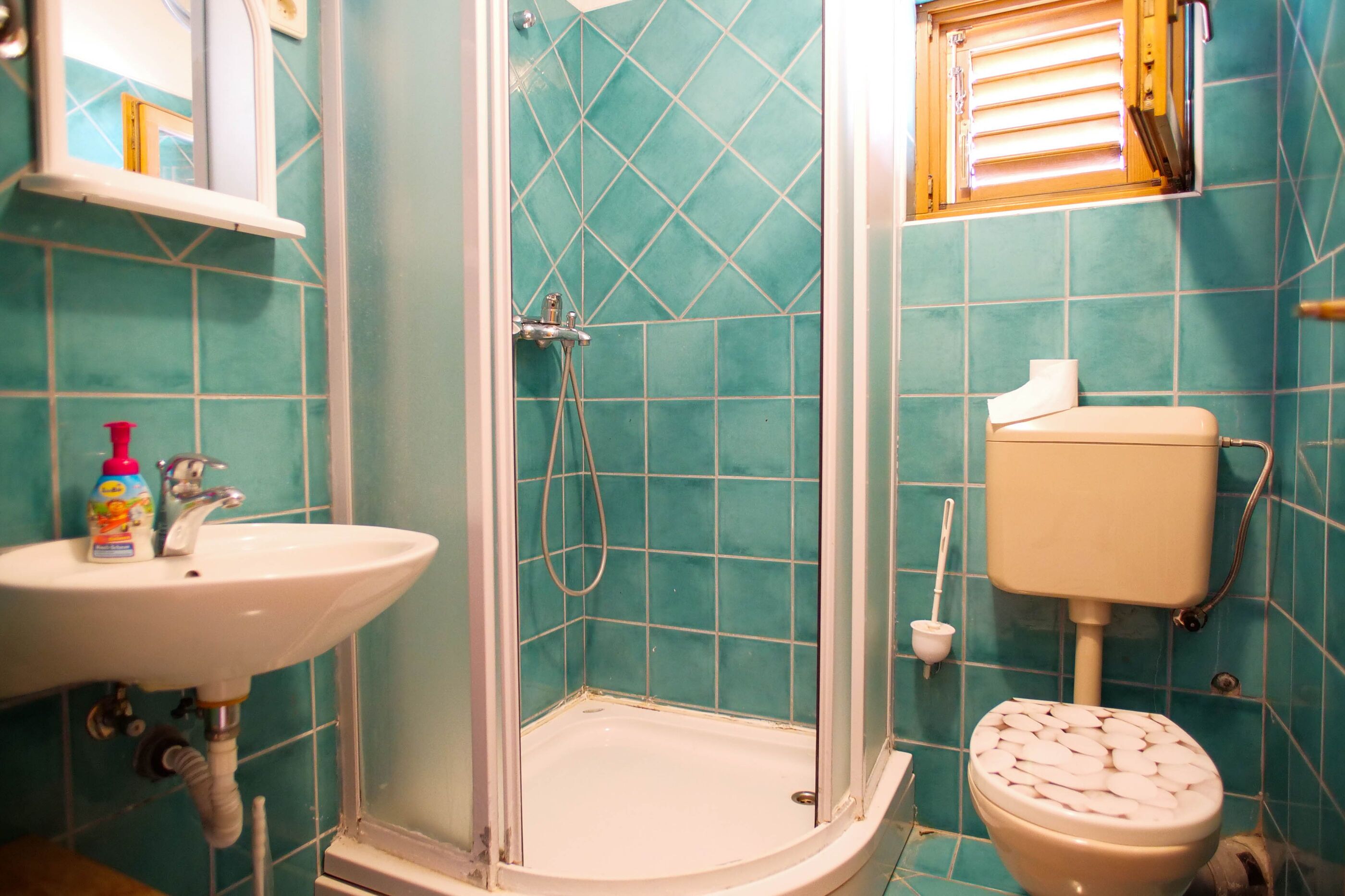 A bathroom with a sink, toilet, and shower.