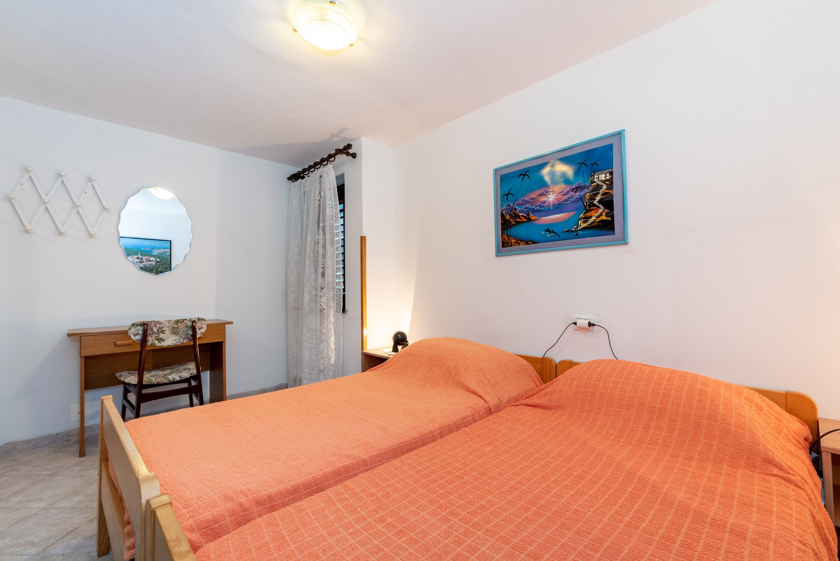 Een slaapkamer met een bed, een bureau en een stoel.