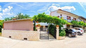 A residential street with houses, a gated driveway, and parked cars. - House Bruno (Pula)