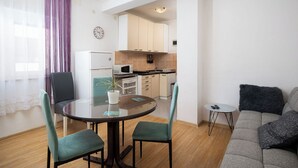 A modern apartment with a dining area, kitchen, and living room. - Apartment Vladimir (Medulin)