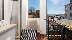 A balcony with a view of the sea, a tiled floor, and a chair. - Apartment Vladimir (Medulin)