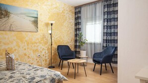 A room with a bed, two chairs, a small table, a lamp, a plant, and a painting on the wall. - Apartment Vladimir (Medulin)