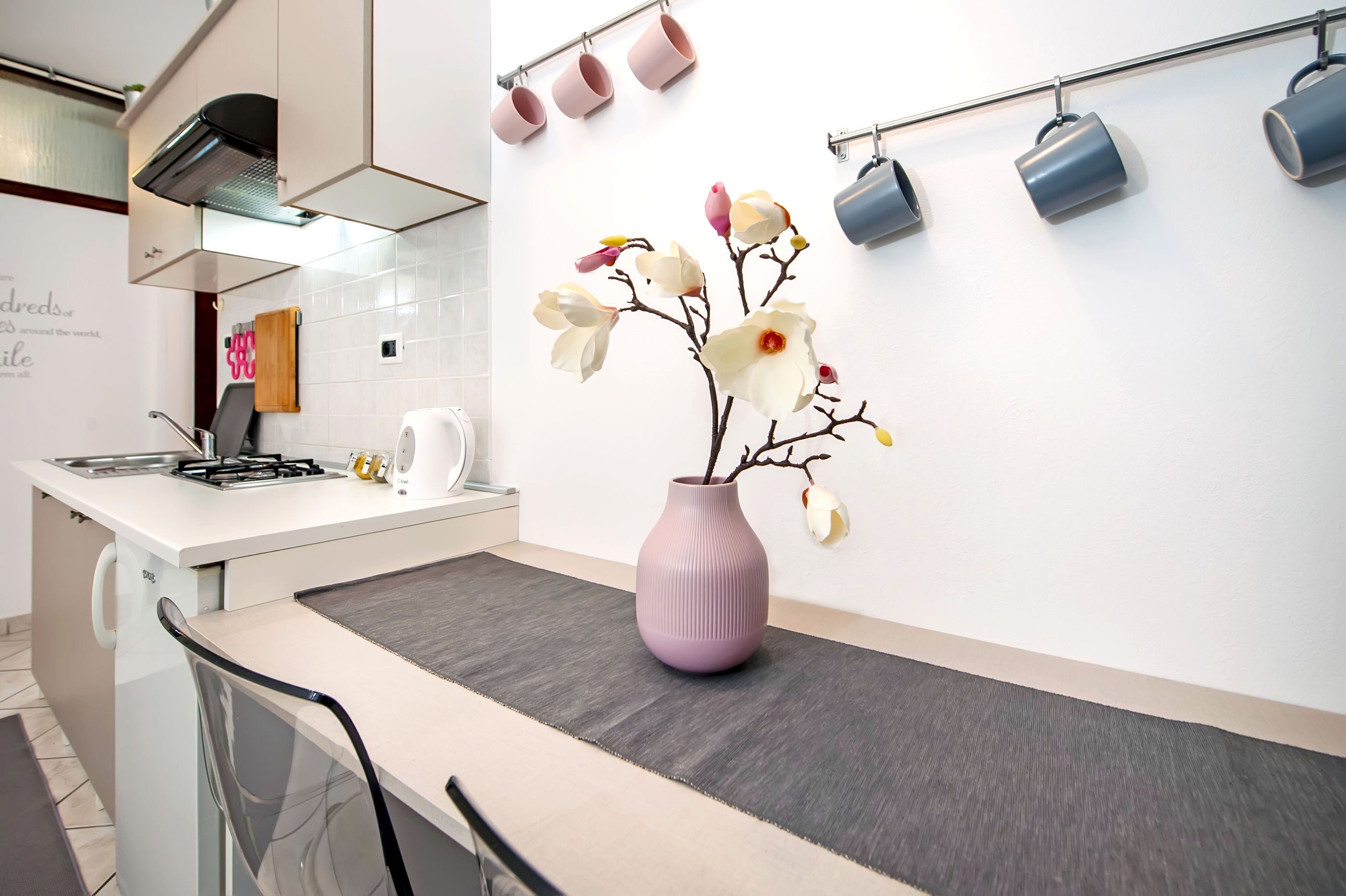 A modern kitchen with a central island, a gas stove, and a stainless steel range hood.