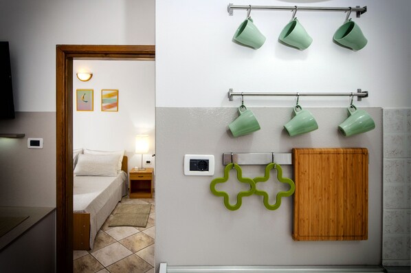 A bedroom with a bed, bedside table, lamp, and a wall-mounted power outlet. - Apartments Milan (Rovinj)