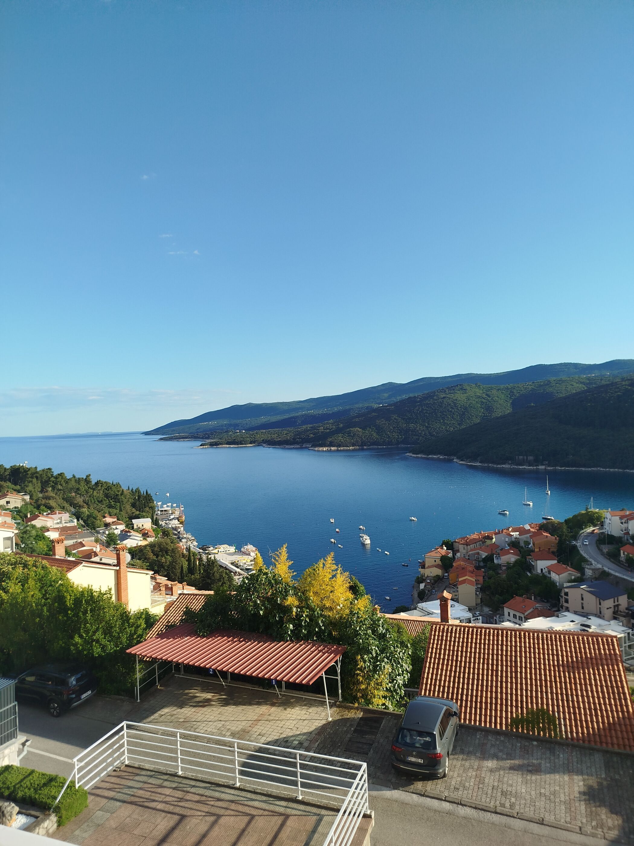 Eine Küstenstadt mit Häusern, blauem Meer und Booten.