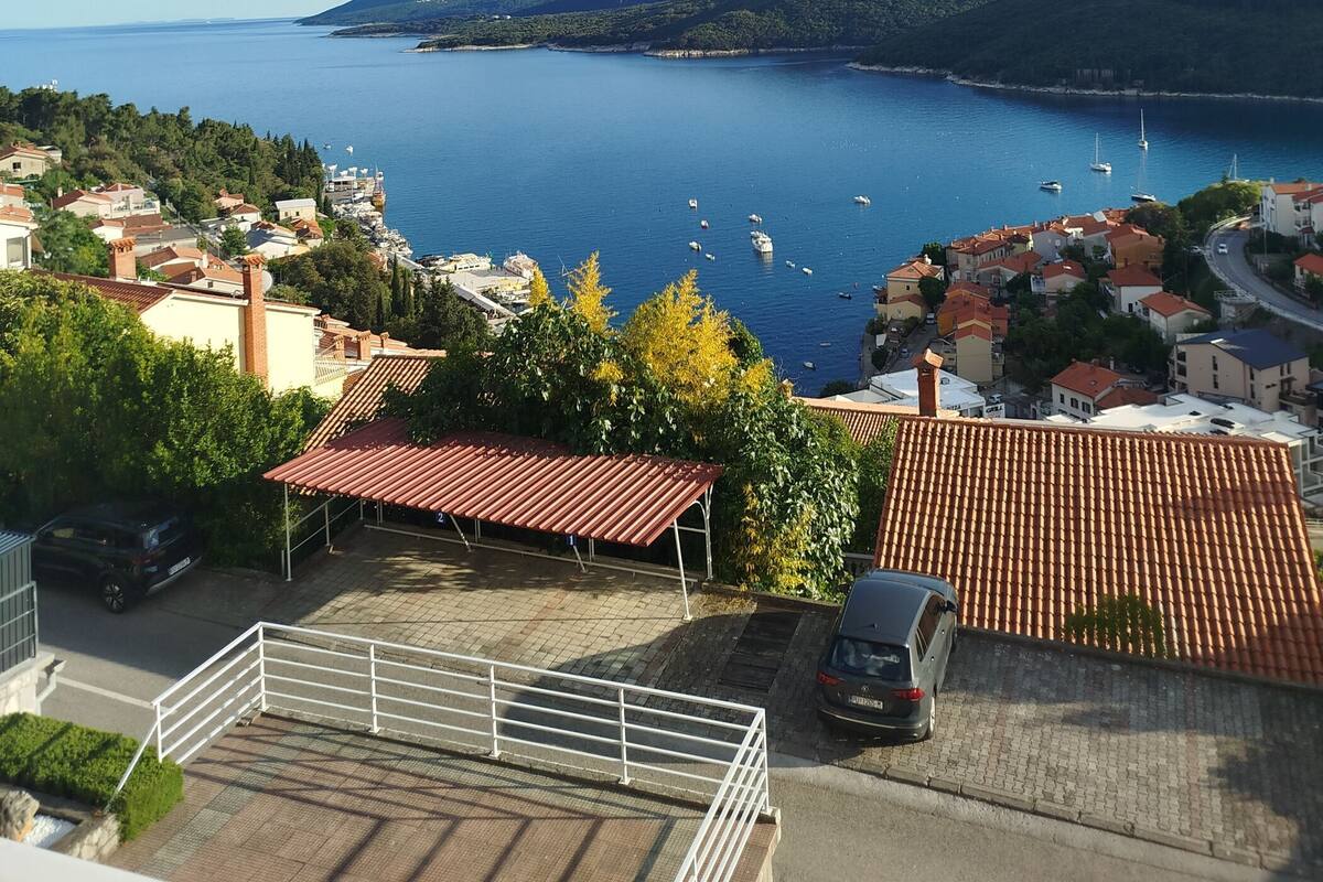 A coastal town with buildings, a clear blue sea, and boats.