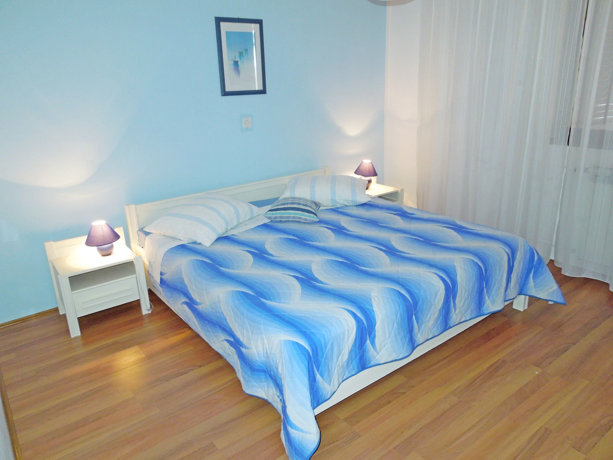 Een slaapkamer met een bed, twee nachtkastjes en een nachttafel.