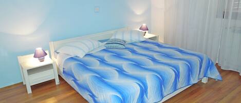 Een slaapkamer met een bed, twee nachtkastjes en een nachttafel.
