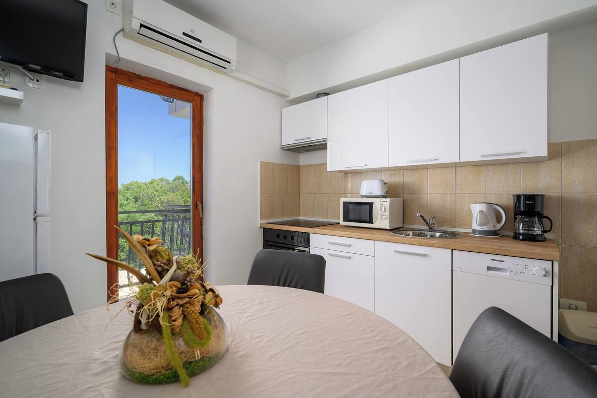 A modern kitchen with white cabinets, a microwave, a coffee maker, and a dishwasher.
