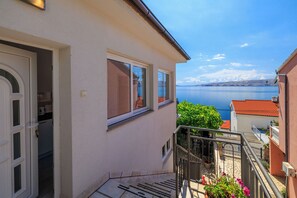 Un bâtiment doté d’un balcon donnant sur une étendue d’eau, d’une porte et d’une fenêtre.