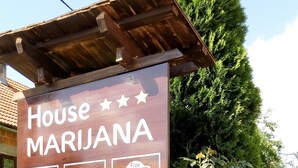 A wooden sign for House Marijuana, indicating amenities like free Wi-Fi, a bed, and a coffee symbol. - House Marijana (Smoljanac)