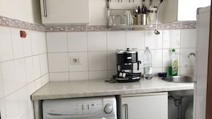A compact kitchen with a built-in washing machine, a coffee maker, and a sink. - Near Termini Station (Rome)