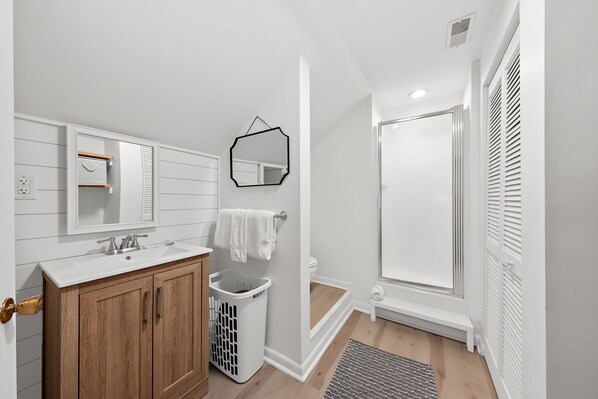 A modern bathroom with a wooden vanity, a mirror, a sink, and a shower. - Pet Friendly 3BR Tarpon Pond Cottage! Close to Beach/Pools (Seabrook Island)