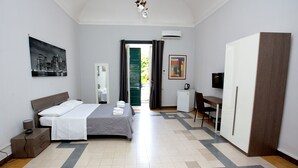 Ein Hotelzimmer mit Bett, Schreibtisch, Kleiderschrank und Fernseher.