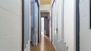 Ein Korridor mit weißen Wänden, einem Fliesenboden und Türen an beiden Seiten.