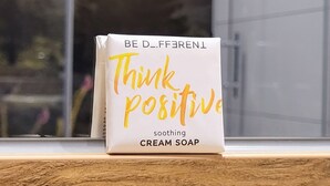 Eine Schachtel beruhigende Seife mit dem Namen 'Think Positive' auf einer Holzoberfläche.