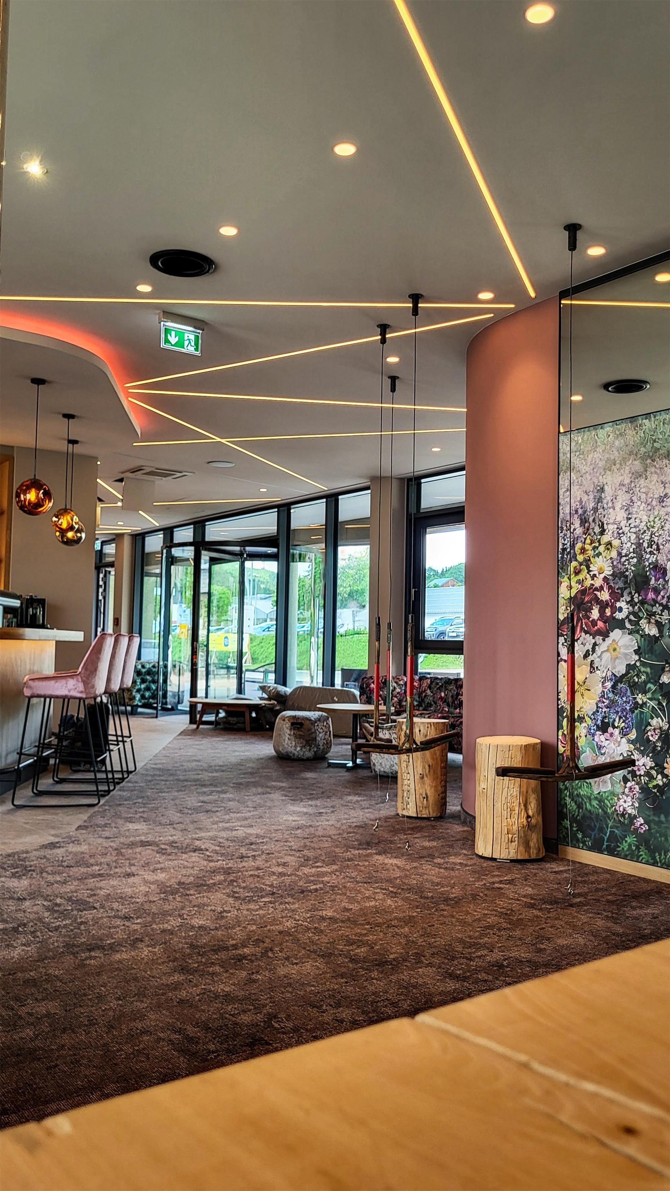 Un interior moderno con una zona de bar, asientos y ventanas amplias.