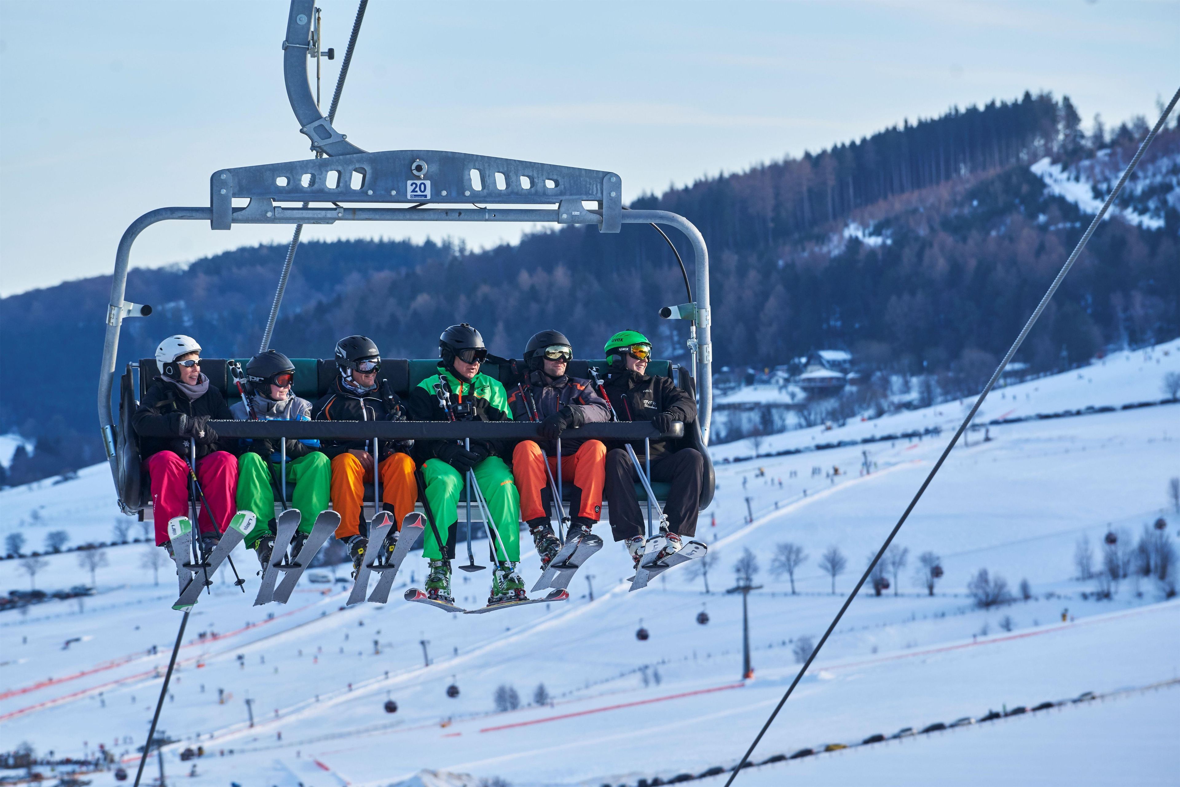 A ski lift carrying skiers in colorful attire.