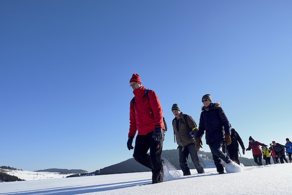 Un grupo de personas caminando por un sendero cubierto de nieve.