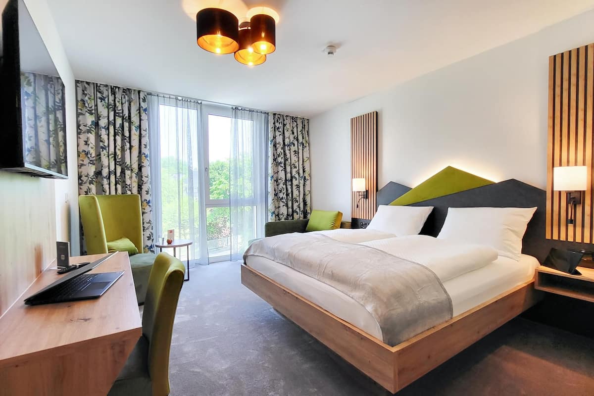 Een moderne hotelkamer met een groot bed, een bureau, een stoel en een televisie.