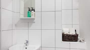 Bañera con ducha, secador de pelo, toallas, shampoo