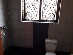 Deluxe tweepersoonskamer | Badkamervoorzieningen | Een douche, pantoffels, handdoeken, zeep