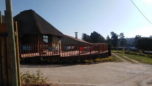 Un edificio con techo de paja y terraza de madera.