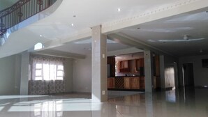 Un espacio amplio y abierto con un techo alto y una escalera que conduce a un nivel superior.
