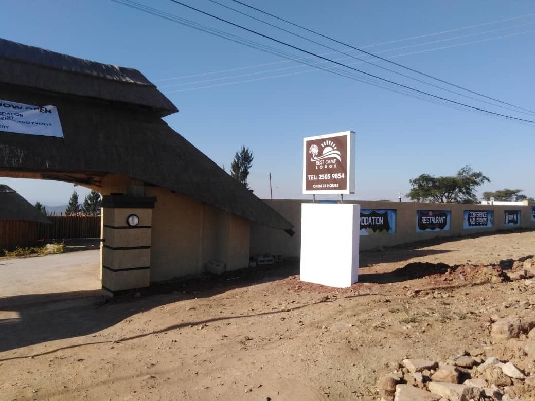 Señal de Best Camp Lodge con un número de contacto y horario de atención.