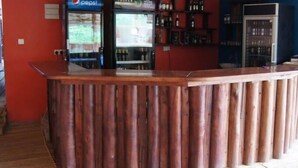En receptionsdisk i trä med ett kylskåp för Pepsi och ett kylskåp för Tusker i bakgrunden.