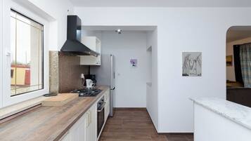 Appartement (A1) | Privékeuken | Een koelkast, een kookplaat, een vaatwasser, kookgerei, borden en bestek