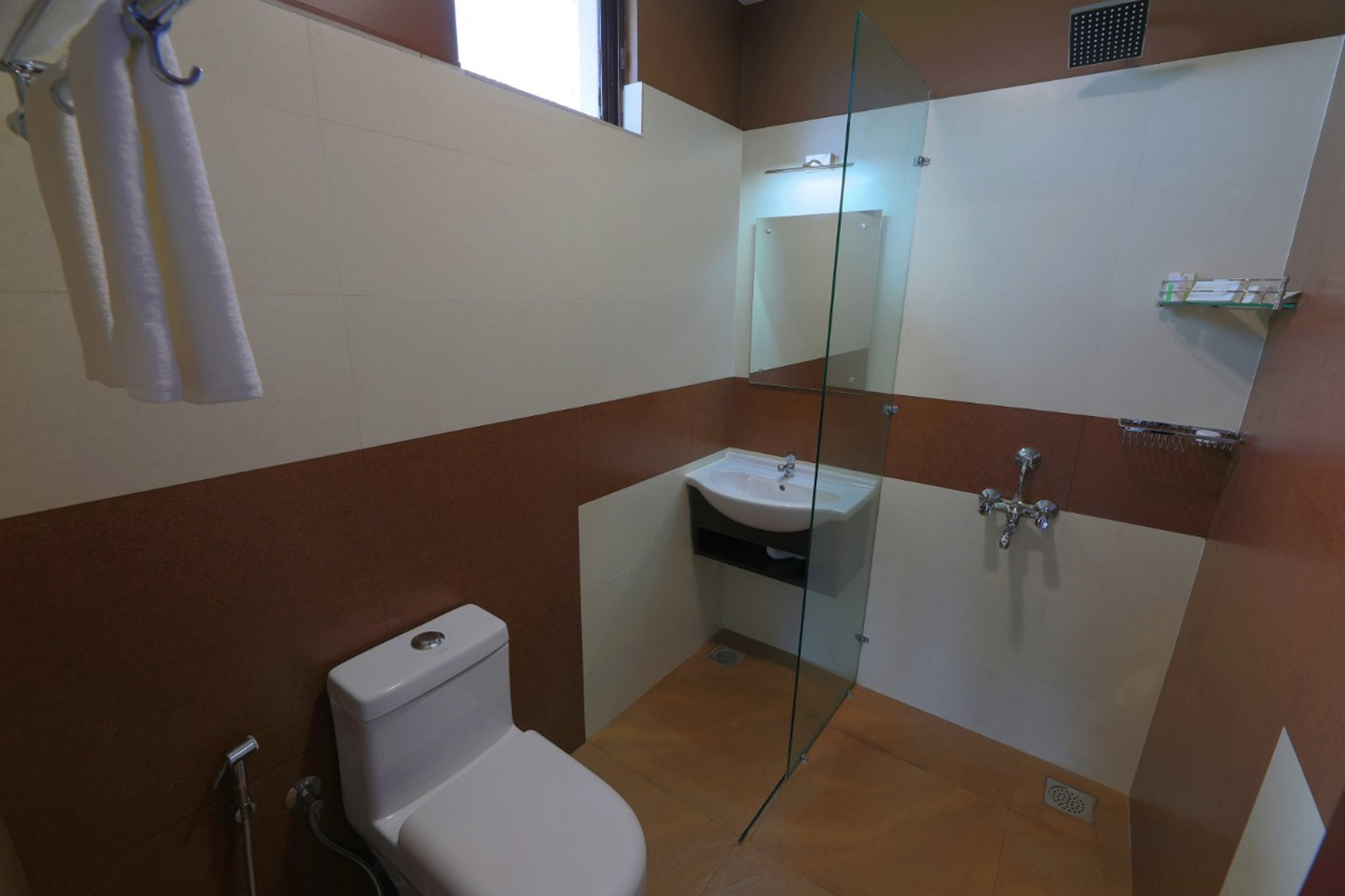 Un baño con inodoro, ducha envuelta en vidrio y lavamanos.