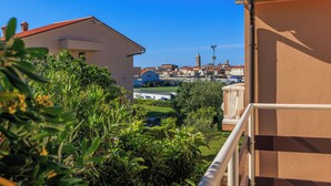 Une vue d’un quartier résidentiel, avec un immeuble doté d’un toit recouvert de tuiles rouges et d’un balcon.