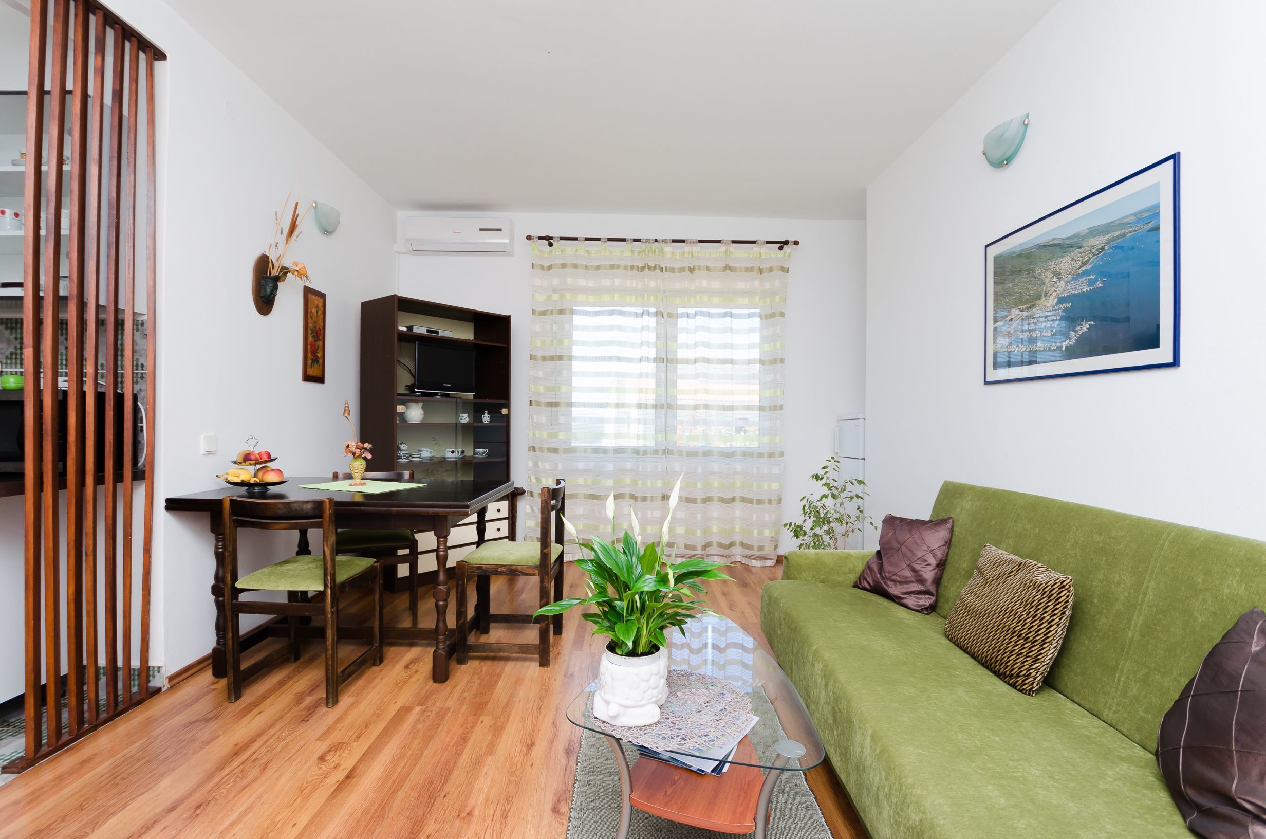 A compact living space with a dining area, a sofa, and a kitchen.