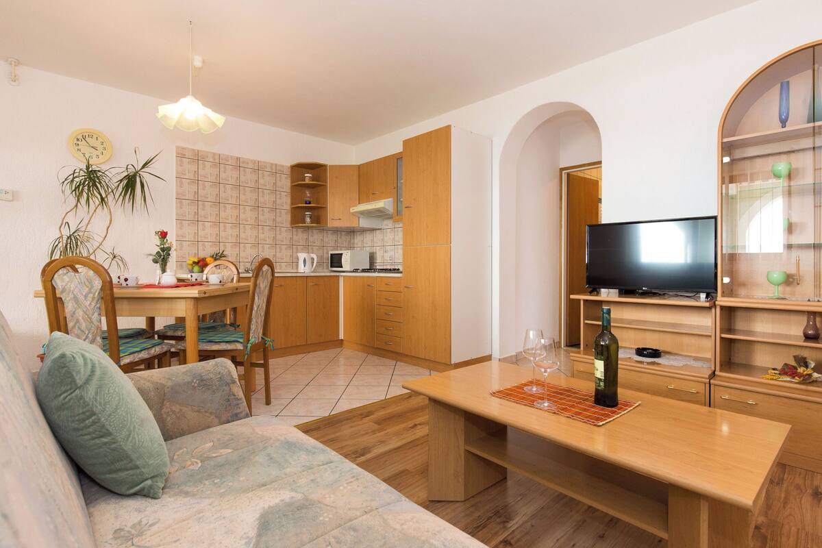 En moderne stue med sofa, sofabord og fjernsyn.