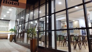 A hotel entrance with large windows, a sign reading "Hotel", and potted plants outside. - Hotel Maestro Express (Francisco Beltrao)