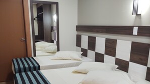A hotel room with two beds, a wooden floor, a mirror, and a wall-mounted light fixture. - Hotel Maestro Express (Francisco Beltrao)