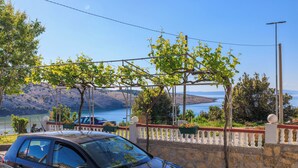 Ένα μαύρο αυτοκίνητο ήταν σταθμευμένο σε μια αυλή, η οποία περιβαλλόταν από έναν τοίχο από πέτρα και ένα λευκό φράχτη.