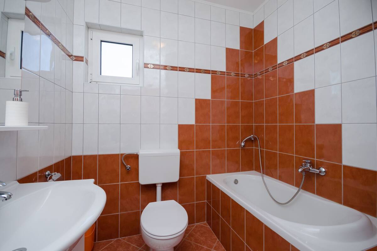 Une salle de bain avec des toilettes, un lavabo et une baignoire.