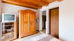 A room with a wooden ceiling, a wardrobe, a television on a stand, and a fan. - House Branka (Supetarska Draga)