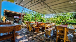 An outdoor patio with wooden furniture and stone flooring. - Apartments Boza (Lopar)
