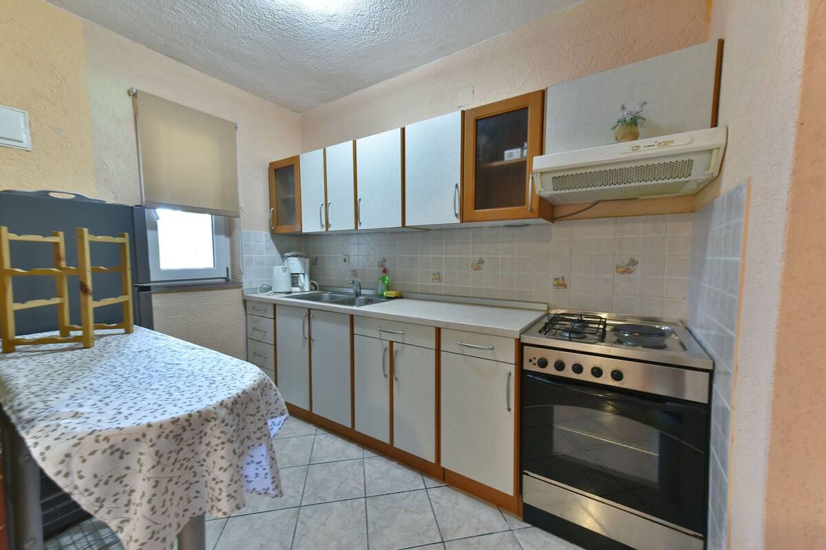 Una cucina compatta con piano cottura a gas, forno e una piccola finestra.