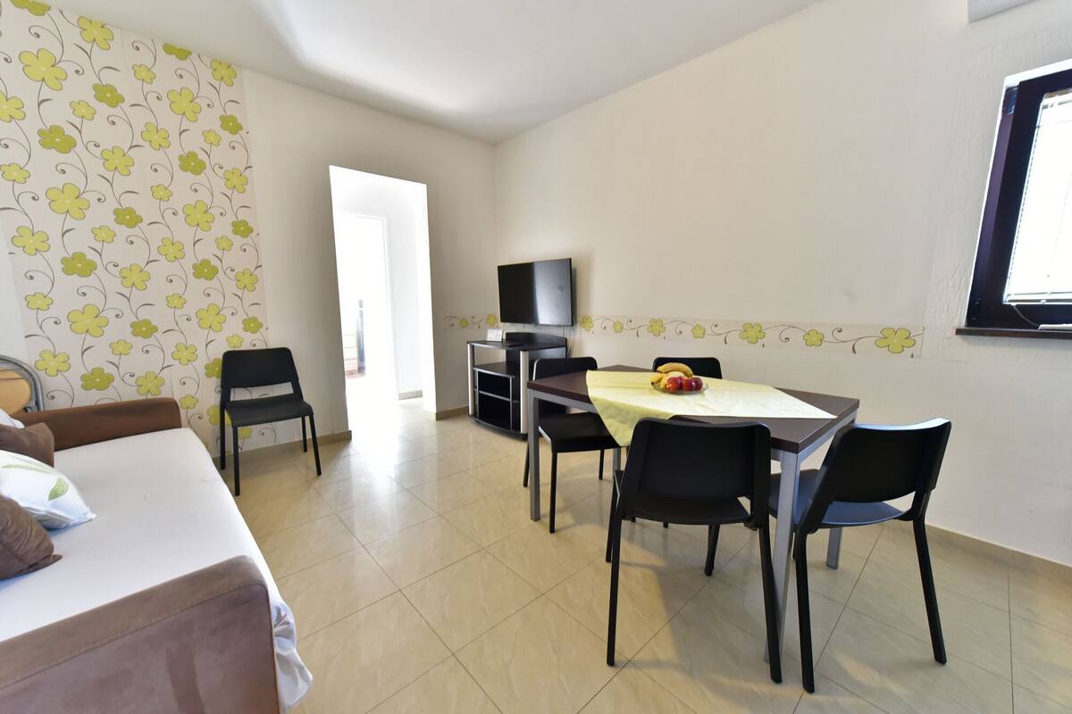 Una camera d'albergo con un letto, una scrivania con una sedia, un televisore e una finestra.