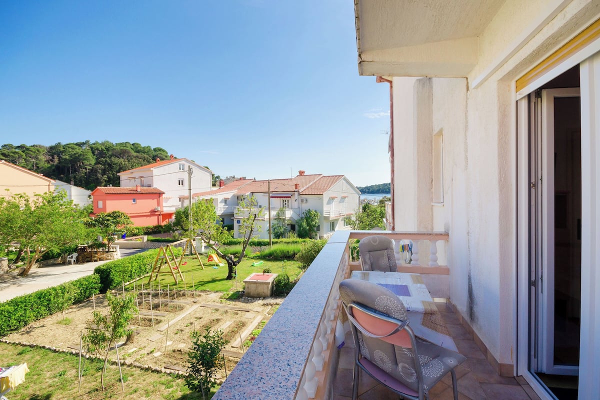 Ein Balkon mit Blick auf eine Wohngegend, einschließlich Häuser und einem Garten.