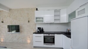 Eine moderne Küche mit weißen Schränken, einer schwarzen Arbeitsplatte und einem eingebauten Backofen.