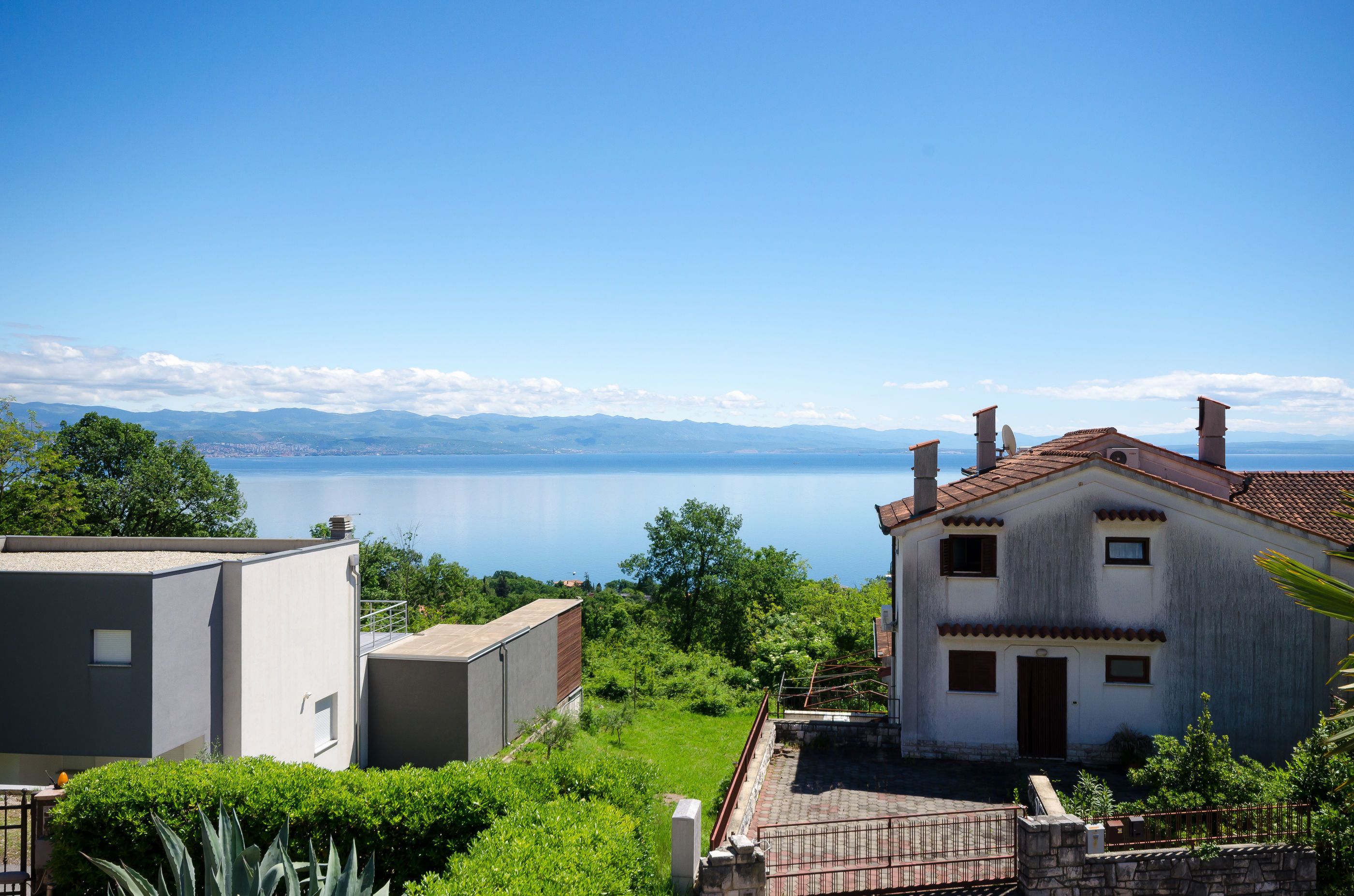 A coastal building with a view of the sea and mountains.