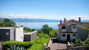 A coastal building with a view of the sea and mountains. - Apartments Zeljko (Lovran)